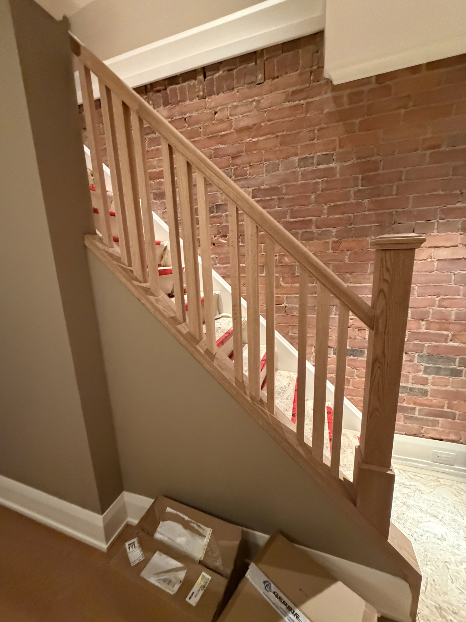 Wooden staircase with brick wall.