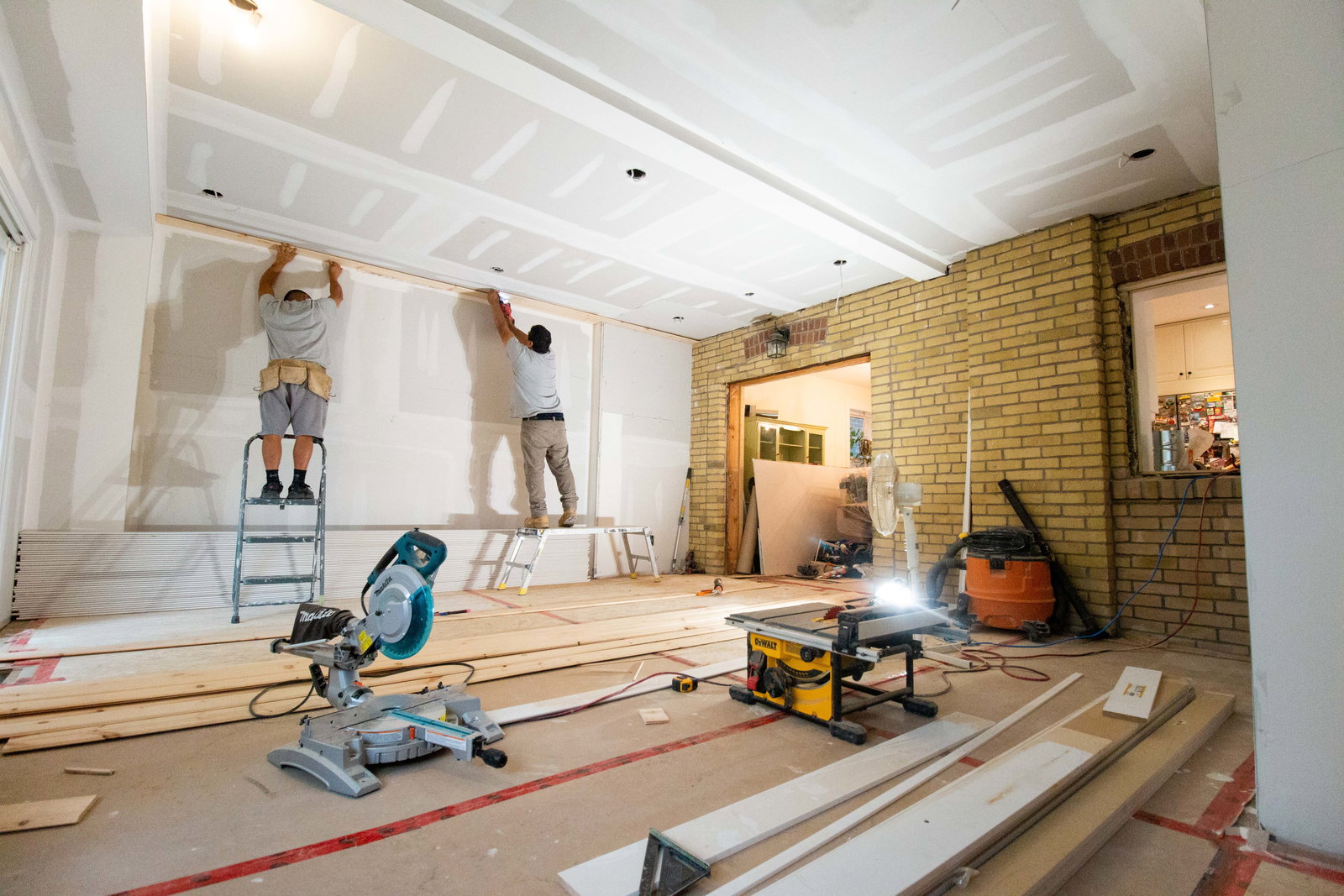 Men renovating a house interior.
